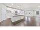 Open-concept kitchen with a white island, stainless steel appliances, pendant lighting, and modern cabinetry, offering a seamless flow at 1103 Freestone Rd, Durham, NC 27703