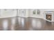 Well-lit living room featuring hardwood floors and a corner fireplace, complemented by neutral-toned walls and natural light at 1103 Freestone Rd, Durham, NC 27703