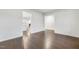 Minimalist design with dark wood floors, with an arched doorway leading to a living space with a fireplace at 1103 Freestone Rd, Durham, NC 27703