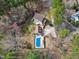 Aerial view of backyard with pool, a detached garage, mature trees, and an expansive driveway at 112 Hartland Ct, Raleigh, NC 27614