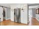 Bright kitchen boasts stainless steel refrigerator, white cabinetry, and hardwood floors at 112 Hartland Ct, Raleigh, NC 27614