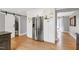 Bright kitchen boasts stainless steel refrigerator, white cabinetry, and hardwood floors at 112 Hartland Ct, Raleigh, NC 27614