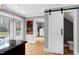 Charming kitchen featuring hardwood floors, view to breakfast room, and sliding barn door to bathroom at 112 Hartland Ct, Raleigh, NC 27614
