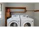 Close up of laundry room features with modern washer and dryer units, and built in shelving at 112 Hartland Ct, Raleigh, NC 27614