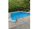 This backyard features an in-ground pool surrounded by a concrete deck and greenery at 112 Hartland Ct, Raleigh, NC 27614