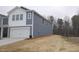 Side angle of a charming two-story home featuring blue siding and a two-car garage at 1120 Solace Way, Rolesville, NC 27571