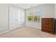 Bright bedroom featuring a window, double door closet, neutral carpet, and a wooden dresser at 114 Mt Evans Dr, Durham, NC 27705