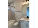 Clean bathroom with tub/shower combo, white vanity with modern hardware, and neutral tile at 12912 Grey Willow Dr, Raleigh, NC 27613