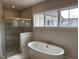 Elegant bathroom with soaking tub, tiled shower, and large windows at 12912 Grey Willow Dr, Raleigh, NC 27613