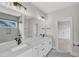 Modern bathroom featuring dual sinks, large mirrors, and a tile shower and floors at 12912 Grey Willow Dr, Raleigh, NC 27613