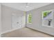 Bright bedroom featuring neutral carpet, double doors, and two windows offering natural light at 12912 Grey Willow Dr, Raleigh, NC 27613