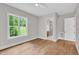Empty bedroom with natural light, hardwood floors, and entry to the ensuite bath and closet at 12912 Grey Willow Dr, Raleigh, NC 27613