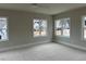 Sunlit bedroom with multiple windows, showcasing neighborhood views and comfortable carpet at 12912 Grey Willow Dr, Raleigh, NC 27613