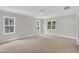 Bright, carpeted bedroom featuring three large windows and a ceiling fan at 12912 Grey Willow Dr, Raleigh, NC 27613