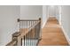 Hallway and staircase featuring wood floors and iron-wrought banisters, with a modern feel at 12912 Grey Willow Dr, Raleigh, NC 27613