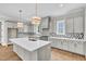 Bright kitchen with quartz countertops, an island with seating, and modern stainless steel appliances at 12912 Grey Willow Dr, Raleigh, NC 27613