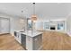 Open kitchen with a large island, stainless steel appliances, and views into the living room at 12912 Grey Willow Dr, Raleigh, NC 27613