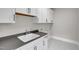 Well-equipped laundry room with modern cabinets, a dark countertop and contemporary fixtures at 12912 Grey Willow Dr, Raleigh, NC 27613