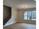 Open living area with hardwood floors, stairs, chandelier, and ample natural light at 12912 Grey Willow Dr, Raleigh, NC 27613