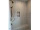 Modern shower with a built-in seat, rainfall shower head, and unique tiled walls at 12912 Grey Willow Dr, Raleigh, NC 27613