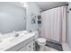 Well-lit bathroom featuring a shower, single sink vanity, and decorative wall art at 166 Hammerstone Dr, Fuquay Varina, NC 27526