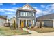 Inviting blue house featuring a bright yellow door, complemented by a well-manicured lawn at 173 E Wilson St, Clayton, NC 27520