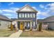 Charming two-story home with blue siding, white trim, a yellow front door, and a well-manicured lawn at 173 E Wilson St, Clayton, NC 27520
