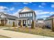 View of a two-story home with a blue facade, white trim and shutters, and a tidy front lawn with landscaping at 173 E Wilson St, Clayton, NC 27520