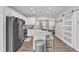 Well-lit kitchen features a center island with barstools, white cabinets, stainless appliances, and wood-look flooring at 173 E Wilson St, Clayton, NC 27520