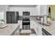 Kitchen showcasing stainless appliances, granite countertops, a tile backsplash, white cabinets, and an island at 173 E Wilson St, Clayton, NC 27520