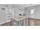 Kitchen island with seating, sliding barn door, decorative mirrors, and open floor plan at 173 E Wilson St, Clayton, NC 27520