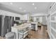 Eat-in kitchen showcases white cabinets, an island with barstool seating, stainless steel appliances, and hardwood flooring at 173 E Wilson St, Clayton, NC 27520