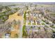 An aerial view of a residential neighborhood showcasing the property's proximity to surrounding homes and streets at 2 Poplar Ave, Elon, NC 27244