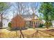Back exterior view of brick home with large backyard and wooden deck at 2 Poplar Ave, Elon, NC 27244