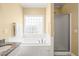 Bathroom with a tub, shower, and bright window at 2 Poplar Ave, Elon, NC 27244