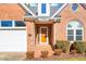 Charming brick home featuring a well-maintained lawn, a front door with sidelights, and a two-car garage at 2 Poplar Ave, Elon, NC 27244