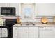 A kitchen featuring white cabinetry, stainless appliances, and a bright window at 2 Poplar Ave, Elon, NC 27244