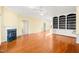 Spacious living room featuring hardwood floors, a fireplace, and built-in shelving at 2 Poplar Ave, Elon, NC 27244