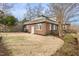 View of the backyard featuring a brick home, privacy fence, and well-maintained lawn and landscaping at 201 W Trinity Ave, Durham, NC 27701