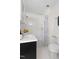 Bright bathroom featuring a white vanity, tub with tile surround, and modern fixtures at 201 W Trinity Ave, Durham, NC 27701
