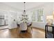 Sunlit dining room with hardwood floors, stylish chandelier, and open access to kitchen at 201 W Trinity Ave, Durham, NC 27701