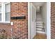Brick entryway with an open door and stairs leading upstairs at 201 W Trinity Ave, Durham, NC 27701