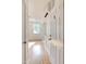 Hallway with light wood floors leading to a window and kitchen area at 201 W Trinity Ave, Durham, NC 27701