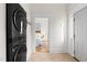 Hallway with stacked washer dryer, entry door, and doorway leading to bedroom at 201 W Trinity Ave, Durham, NC 27701