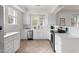Well-lit kitchen with white cabinetry, stainless steel appliances, and tile flooring at 201 W Trinity Ave, Durham, NC 27701