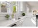 Modern kitchen with white countertops, brass faucet, and ample natural light at 201 W Trinity Ave, Durham, NC 27701
