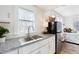 Well-lit kitchen featuring a stainless sink, stainless steel refrigerator and granite countertops at 201 W Trinity Ave, Durham, NC 27701