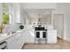 Bright kitchen with stainless steel appliances, white cabinets, and gold fixtures at 201 W Trinity Ave, Durham, NC 27701