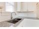 Close up of a kitchen sink with gray countertops and white cabinets at 201 W Trinity Ave, Durham, NC 27701