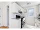 Well-lit kitchen with granite countertops, stainless steel appliances, and sleek white cabinetry at 201 W Trinity Ave, Durham, NC 27701